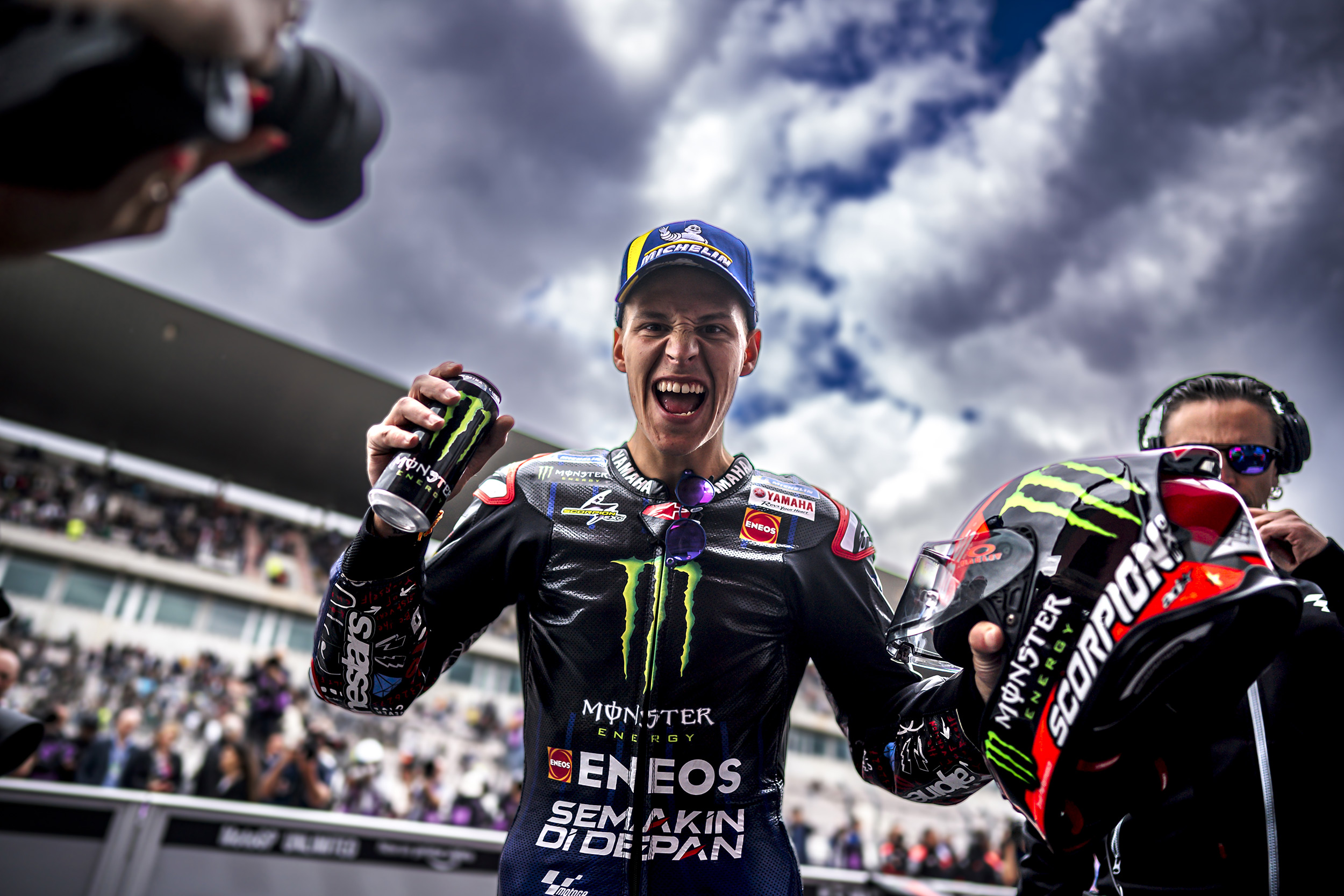 motogp-rider-holding-his-helmet-as-he-smiles-at-the-camera.jpeg