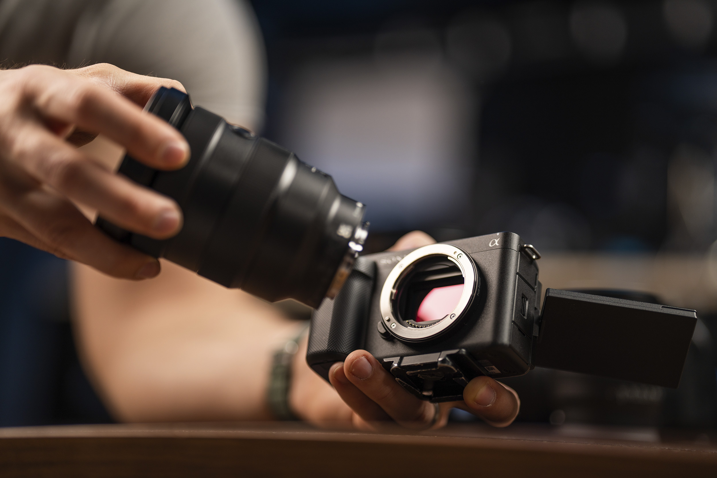 man-attaching-a-lens-to-a-sony-zve1.jpg