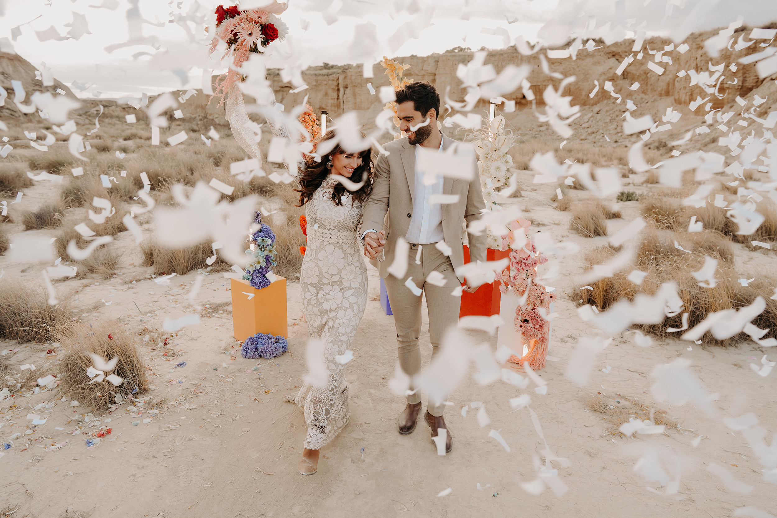 wedding-couple-engulfed-in-confetti-as-they-walk-hand-in-hand.jpg